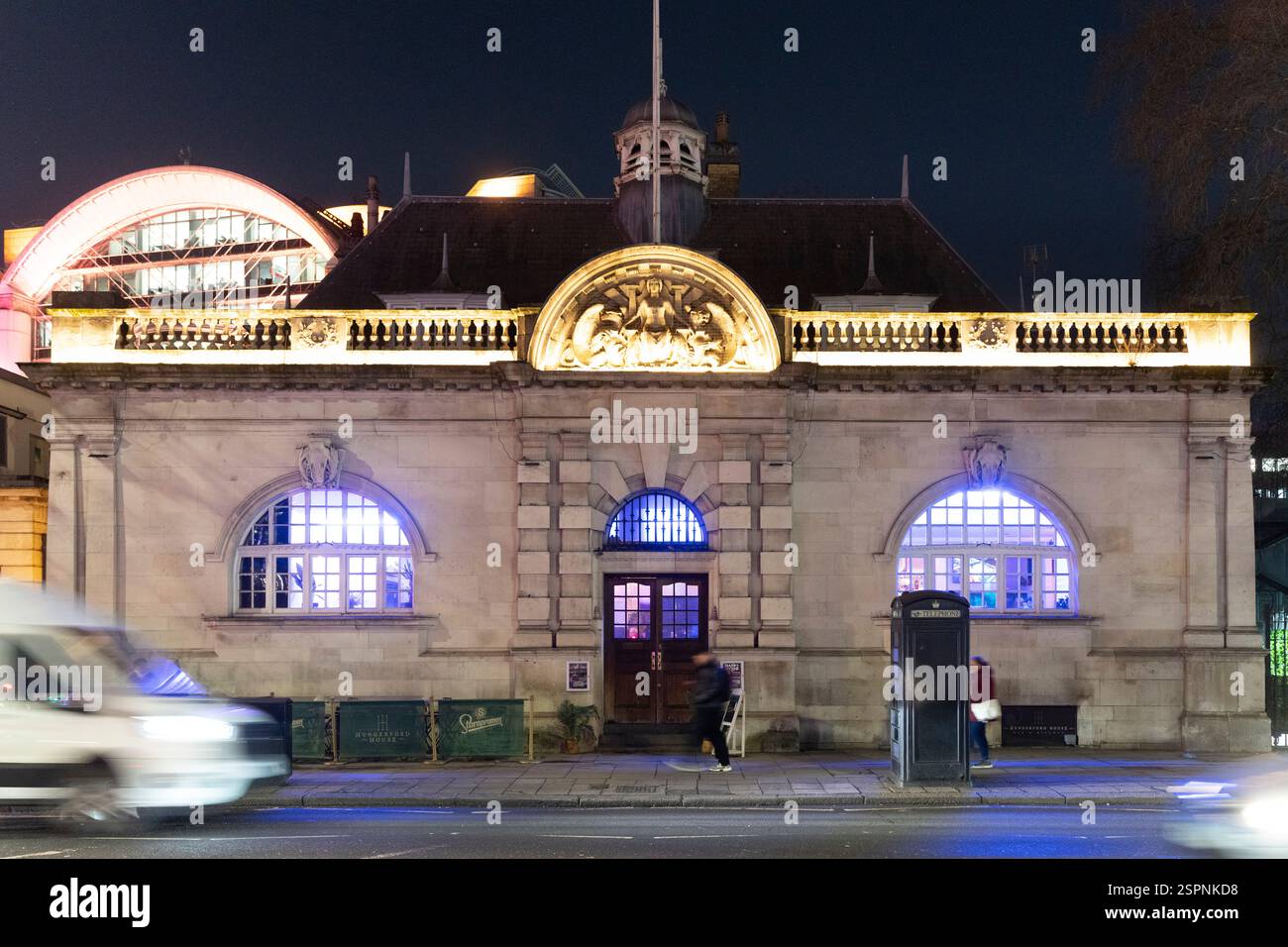 Vista notturna di Hungerford House, un pub, Londra. Finestre ad arco illuminate e facciata decorativa. Foto Stock