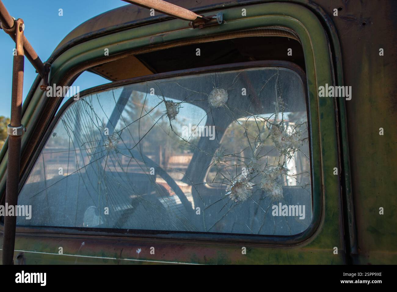 La rottura del vetro del finestrino laterale sinistro di un vecchio camion verde. Foto Stock