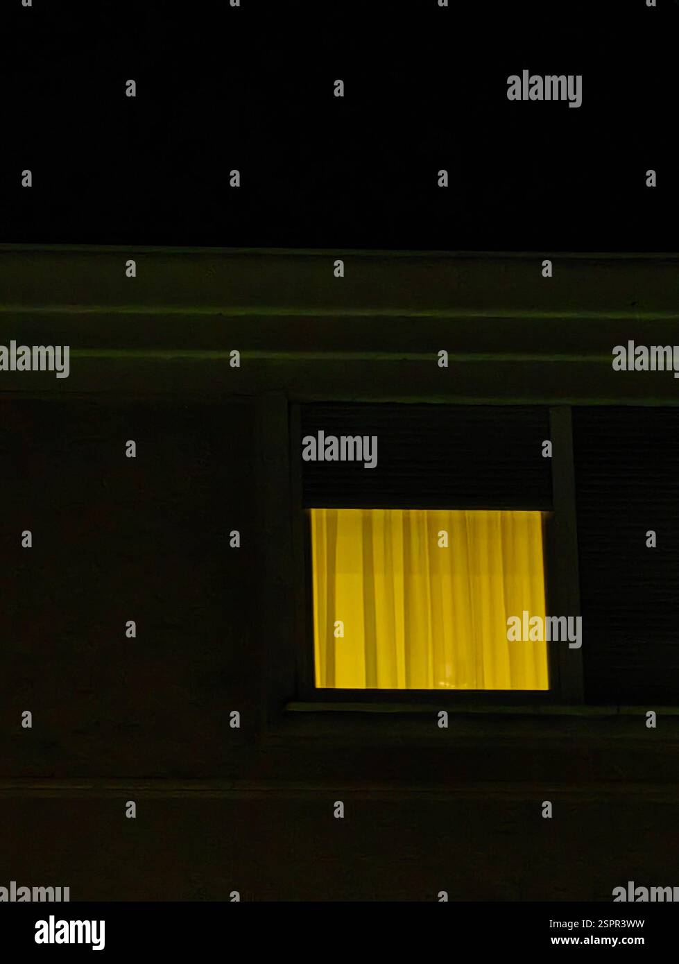 Golden Glow – tende dei finestrini illuminate di notte Foto Stock