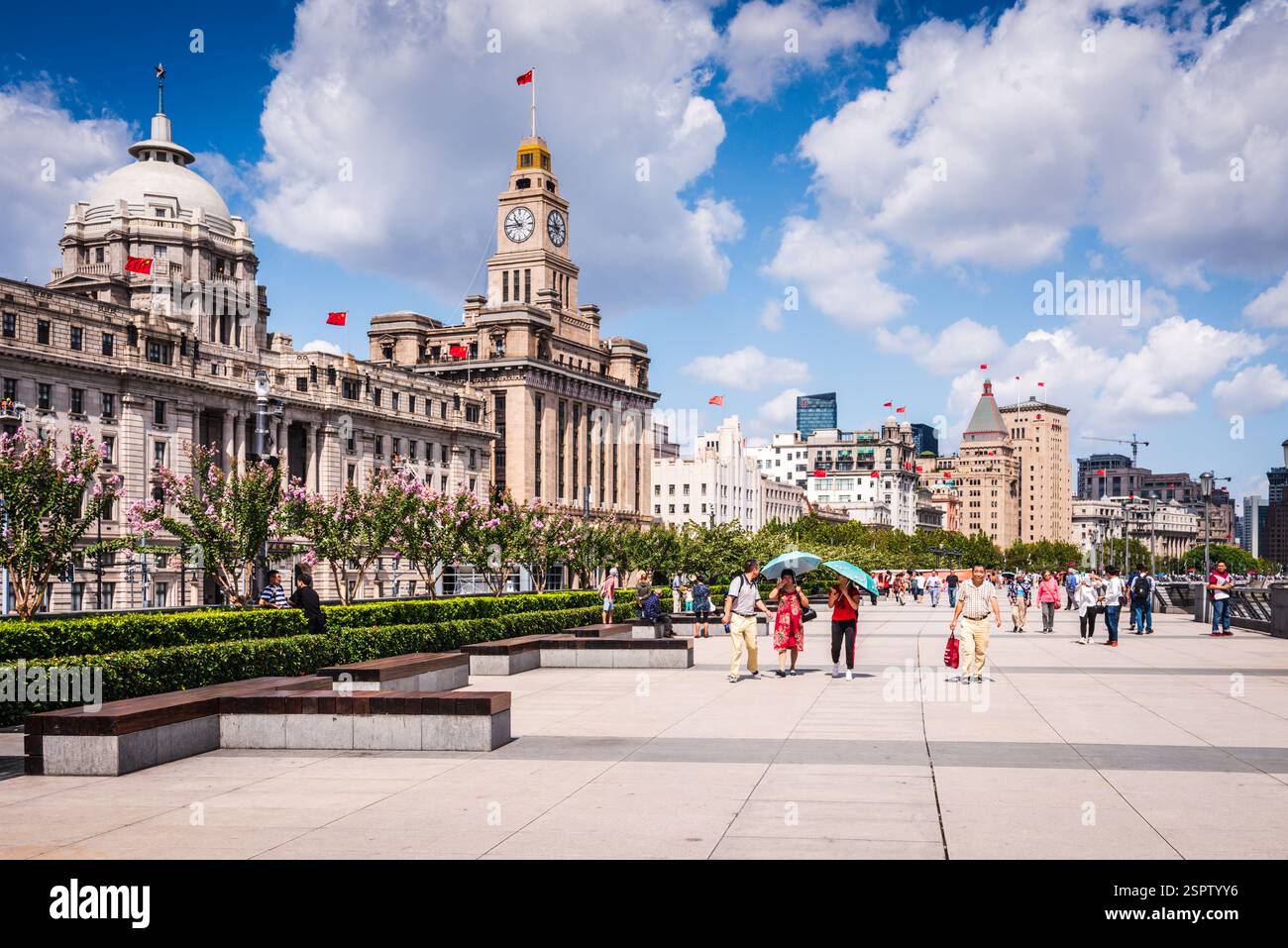 Pedoni che passeggiano lungo il Bund, una famosa passeggiata sul lungomare costeggiata da edifici di epoca coloniale, Shanghai, Cina. Foto Stock