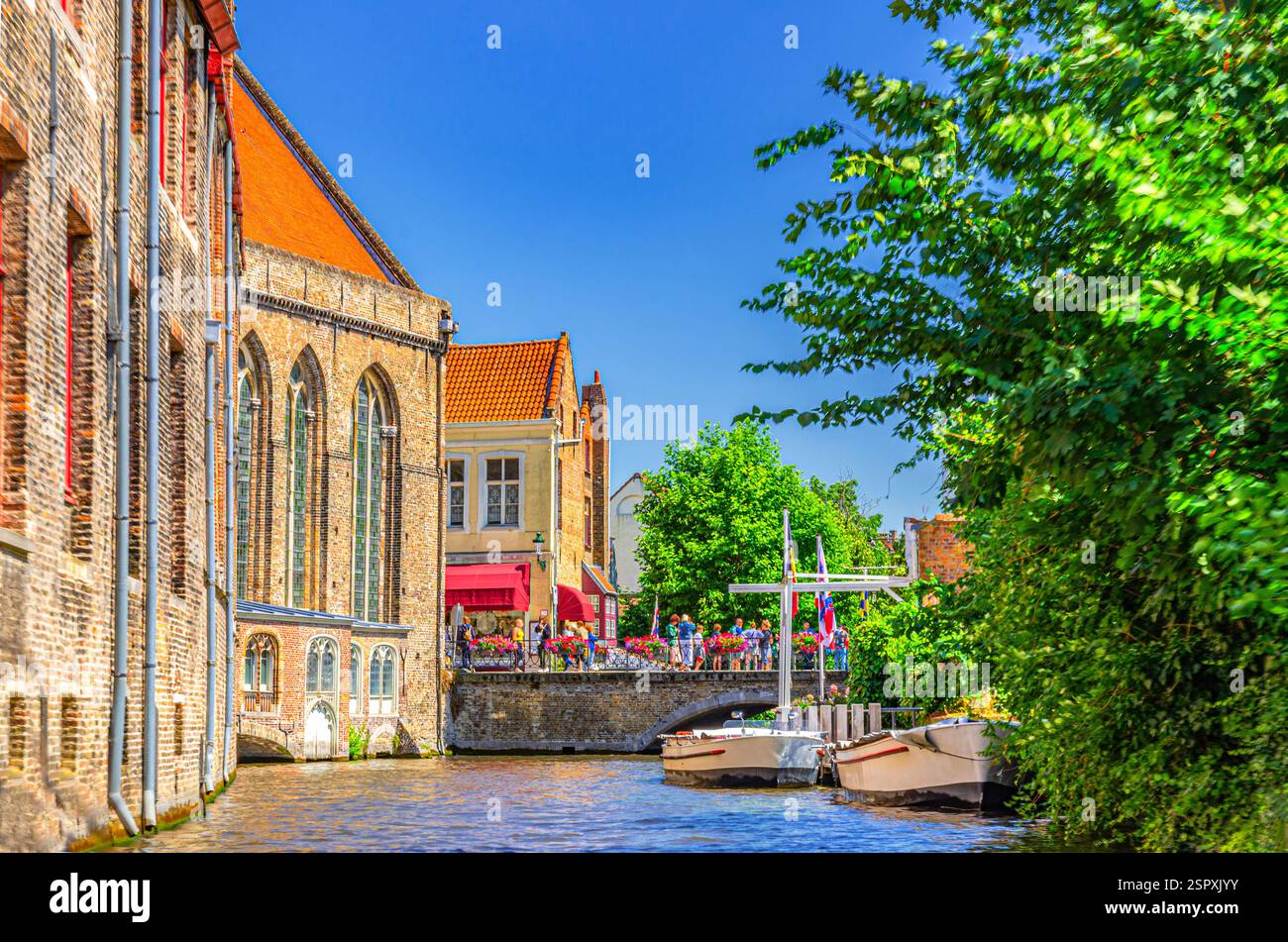 Il canale d'acqua di Bakkersrei, il ponte di Mariabrug e l'edificio del Museo Sint-Janshospitaal con alberi verdi nel quartiere storico di Bruges, la città storica di Bruges Foto Stock