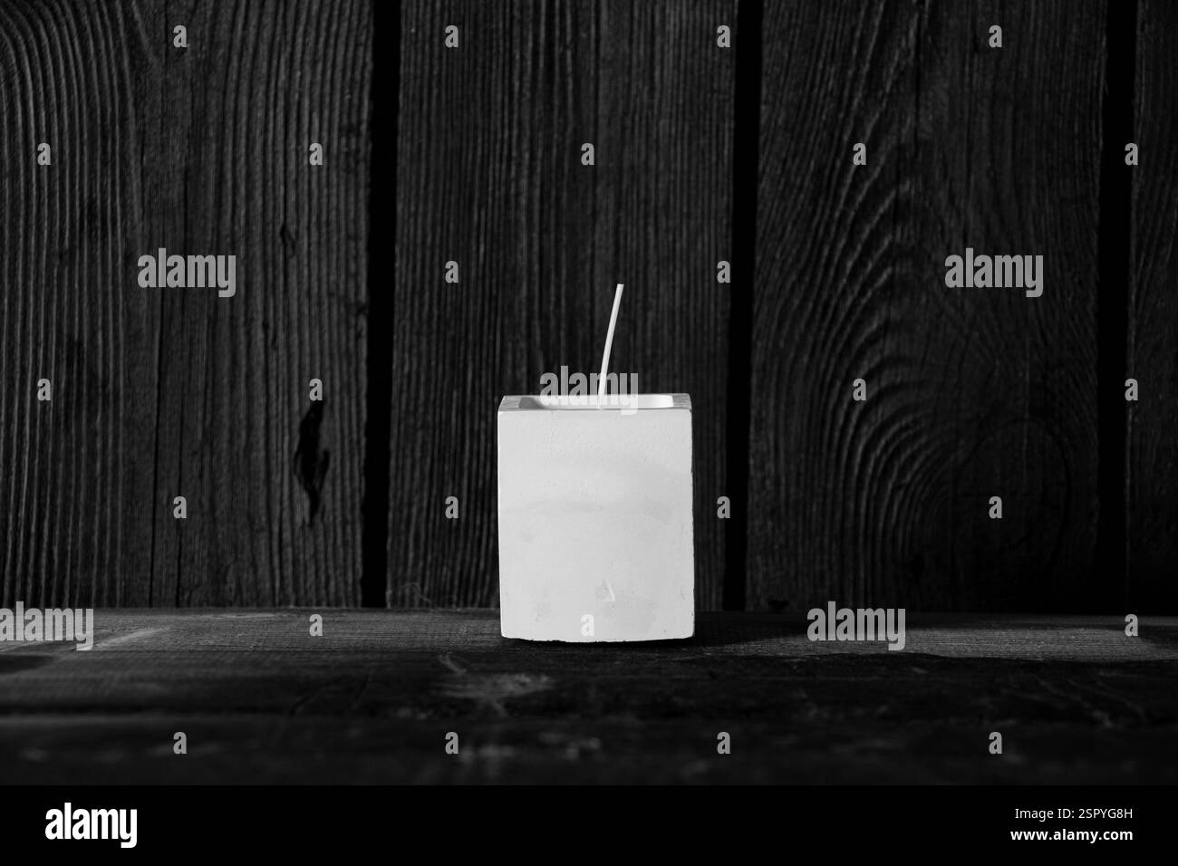 Candela fatta in casa in gesso quadrato sul tavolo, foto in bianco e nero, candela, arredamento per la casa Foto Stock