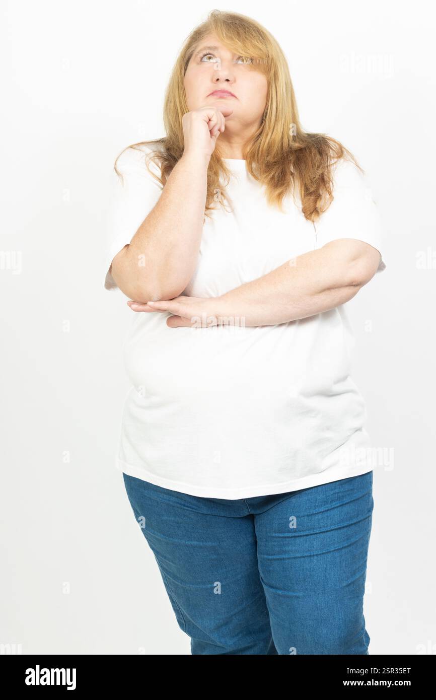 Ritratto di una donna bionda più dimensioni con un'espressione premurosa, che poggia il mento sulla mano. Foto Stock