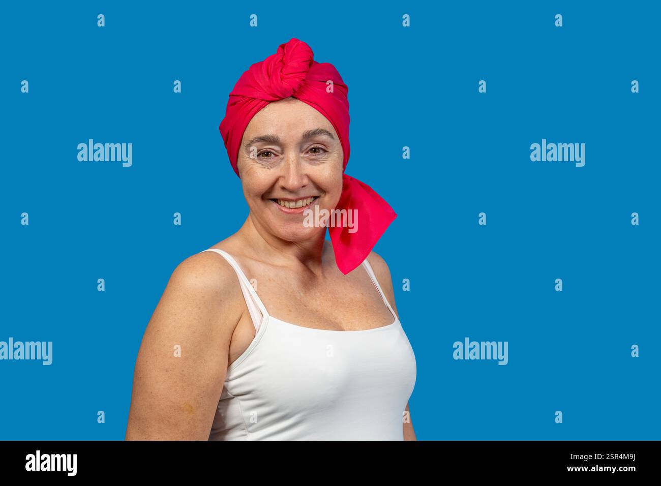 Ritratto di una donna matura sorridente che indossa il velo rosso, che rappresenta il benessere, la forza e la positività Foto Stock