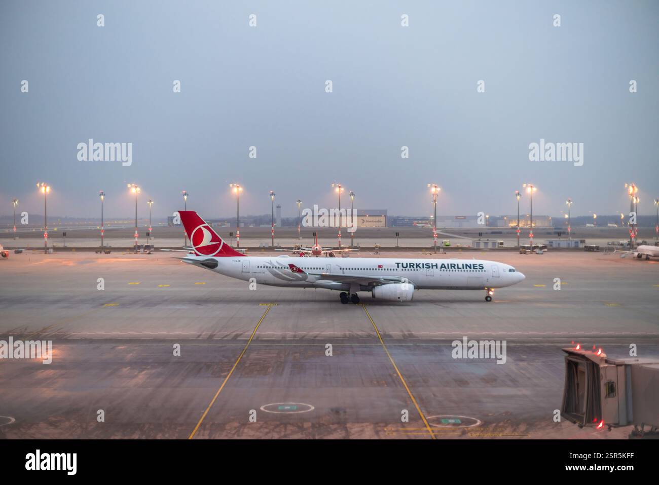 Berlino, Germania. 12 febbraio 2025. Un Airbus A330-300 di Turkish Airlines si trova in una posizione di tenuta in un pomeriggio invernale nebbioso, grigio e noioso all'aeroporto BER di Berlino-Brandeburgo, in Germania. Foto Stock