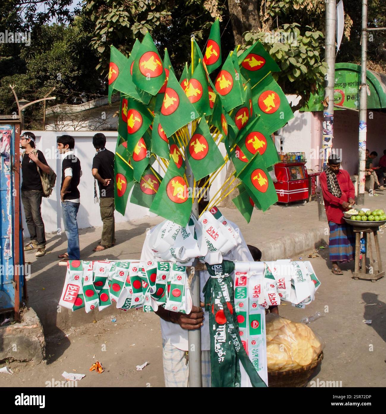 Venditore ambulante che vende merci patriottiche durante le celebrazioni di febbraio di Ekushey a Dacca, in commemorazione del movimento linguistico del Bangladesh. Foto Stock