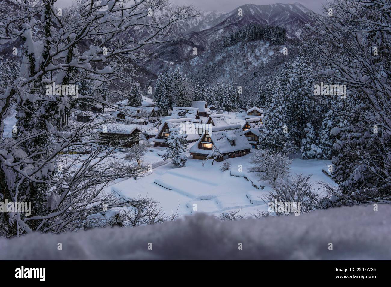 Il villaggio di Ainokura si illumina sotto la notte d'inverno, con le tradizionali case Gassho-zukuri coperte di neve Foto Stock