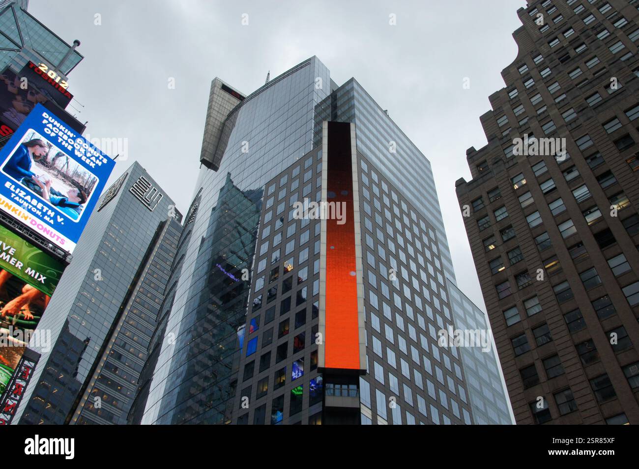 Manhattan si restringe sotto i giganti digitali. Una figura solitaria svanita da schermi scintillanti, beve nella sinfonia urbana. Questa scena trascende Times Squ Foto Stock