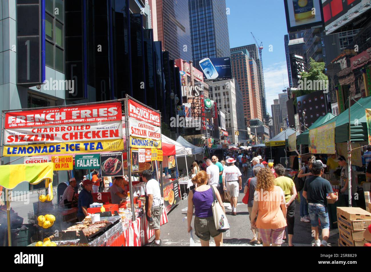 Un menu fast food luminoso offre opzioni allettanti a New York, Manhattan. Patatine fritte dorate, pollo croccante, soffice pane pita e rinfresco Foto Stock