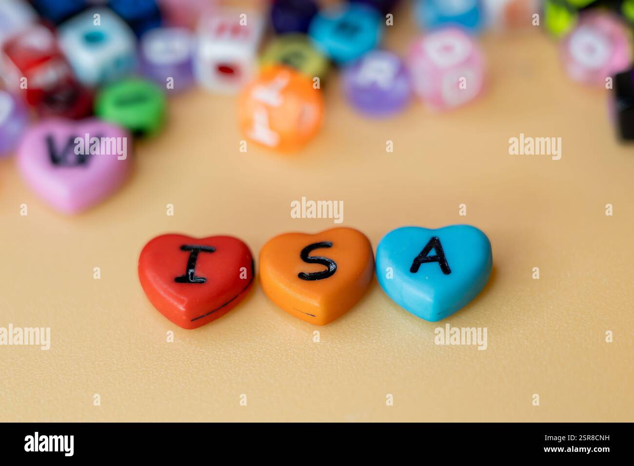 Colorful Hearts with Letters of ISA, i S A, conto di risparmio individuale su sfondo beige circondato da piccole perline decorative, risparmi esentasse Foto Stock
