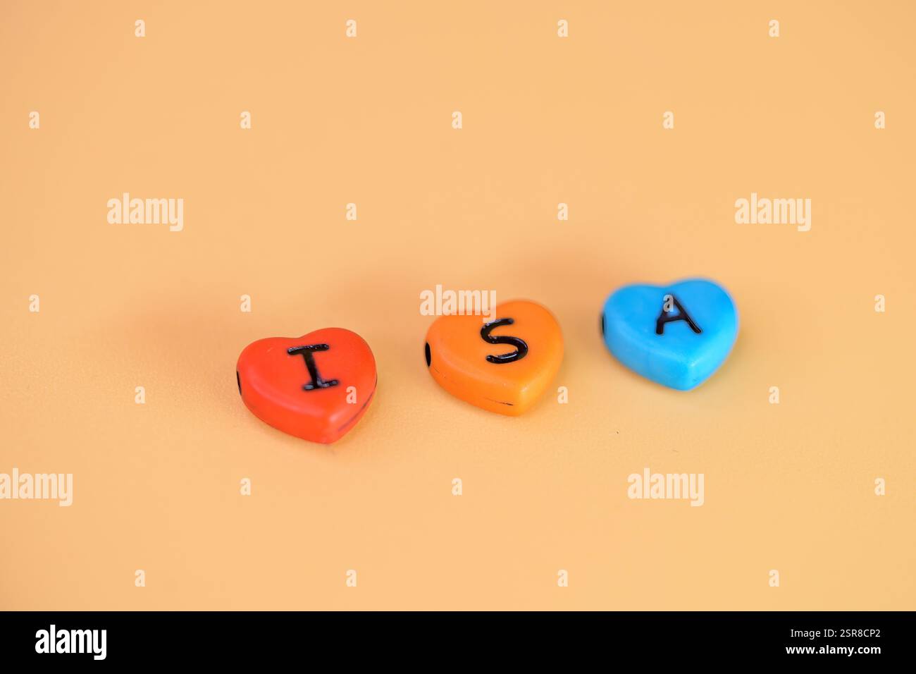 Perline colorate con lettere di ISA, i S A, conto di risparmio individuale su sfondo beige, risparmi esenti da tasse Foto Stock