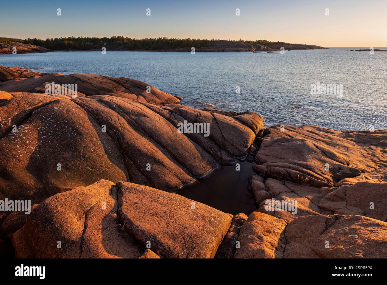 Paesaggio panoramico di una scogliera rocciosa sul mare nelle isole Åland, Finlandia, in una serata di sole in estate. Fuori dai sentieri battuti nella natura. Foto Stock