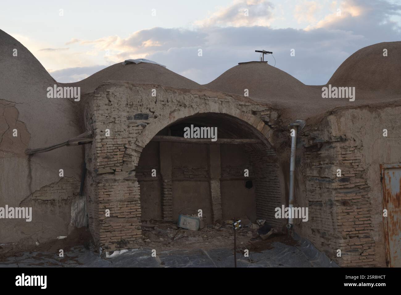 Tradizionale casa a cupola in mattoni di fango in Iran al tramonto, che mostra la storica architettura persiana del deserto con texture di terra Foto Stock Tradizionale casa a cupola in mattoni di fango in Iran al tramonto, che mostra la storica architettura persiana del deserto con texture di terra Foto Stock