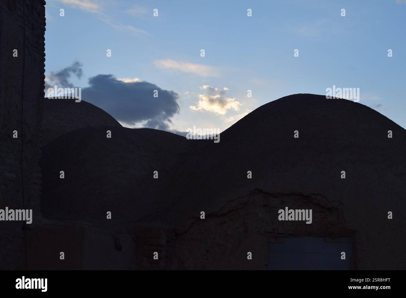 Tradizionale casa a cupola in mattoni di fango in Iran al tramonto, che mostra la storica architettura persiana del deserto con texture di terra Foto Stock Tradizionale casa a cupola in mattoni di fango in Iran al tramonto, che mostra la storica architettura persiana del deserto con texture di terra Foto Stock