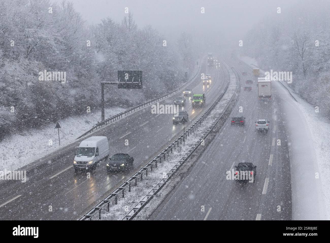 Autostrada innevata con veicoli in movimento e alberi innevati sul ciglio della strada, Winnenden, Baden-Wuerttemberg, Germania, Europa Foto Stock