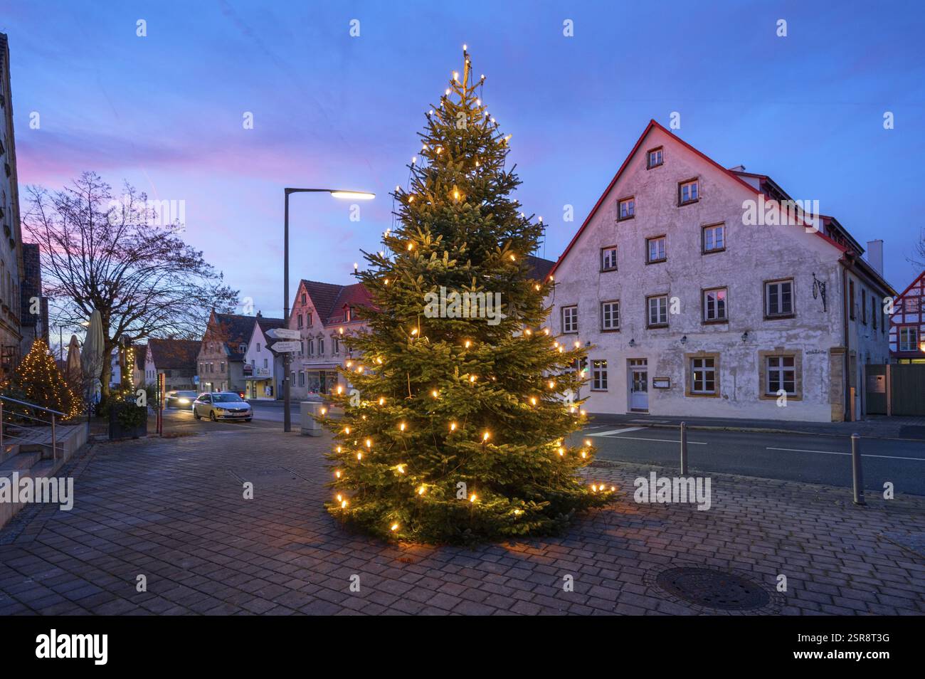 Albero di Natale illuminato sulla piazza del paese al crepuscolo, Eschenau, Franconia media, Baviera, Germania, Europa Foto Stock