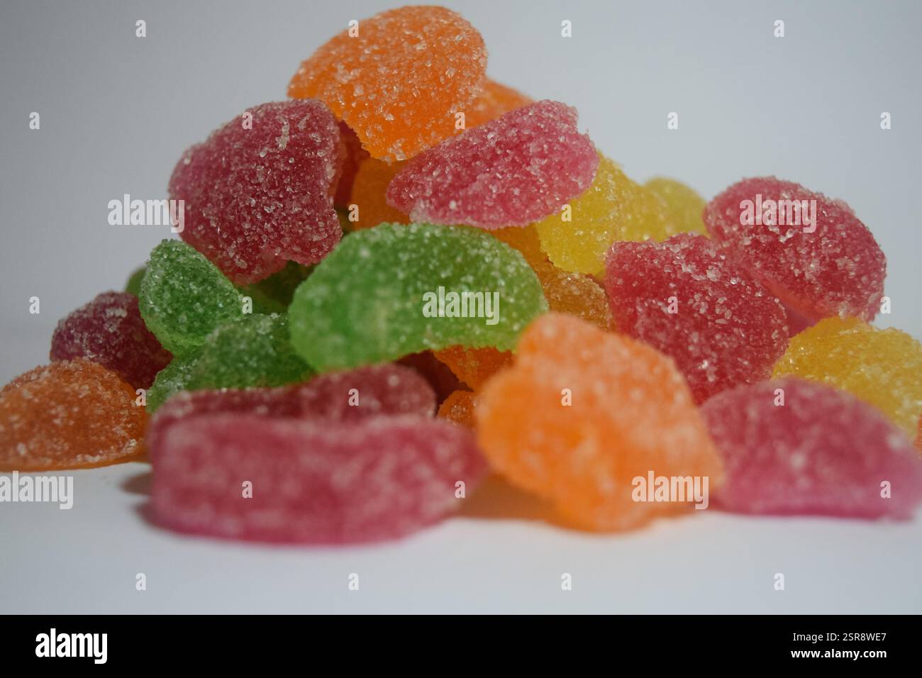 Concediti questo vivace dessert con briciole di velluto rosso e caramelle gommose colorate, perfette per le tue voglie dolci e per la fotografia di cibo Foto Stock