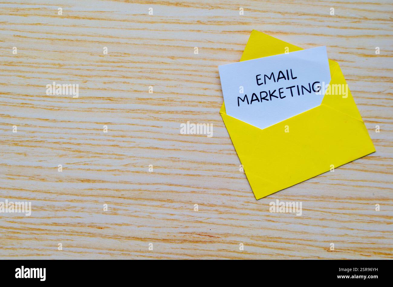 Testo di marketing tramite e-mail su blocco note bianco in una busta gialla con spazio personalizzabile per il testo Foto Stock