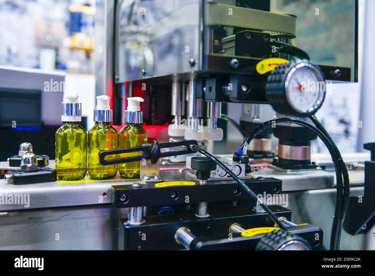 Bottiglie di vetro in un nastro trasportatore su una macchina di riempimento verticale automatica di alta qualità. Nella linea di produzione della fabbrica Foto Stock
