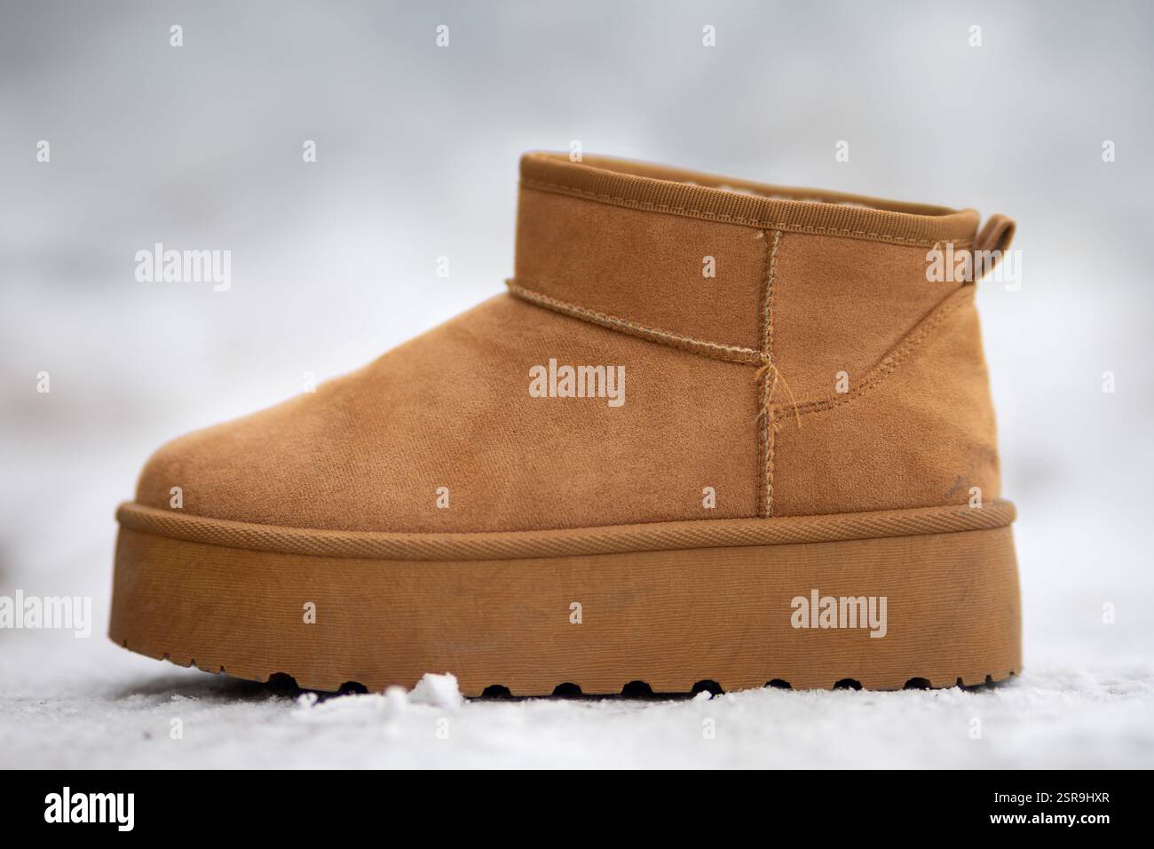 Stivali ugg marroni eleganti e comodi su una superficie innevata, perfetti per le basse temperature Foto Stock