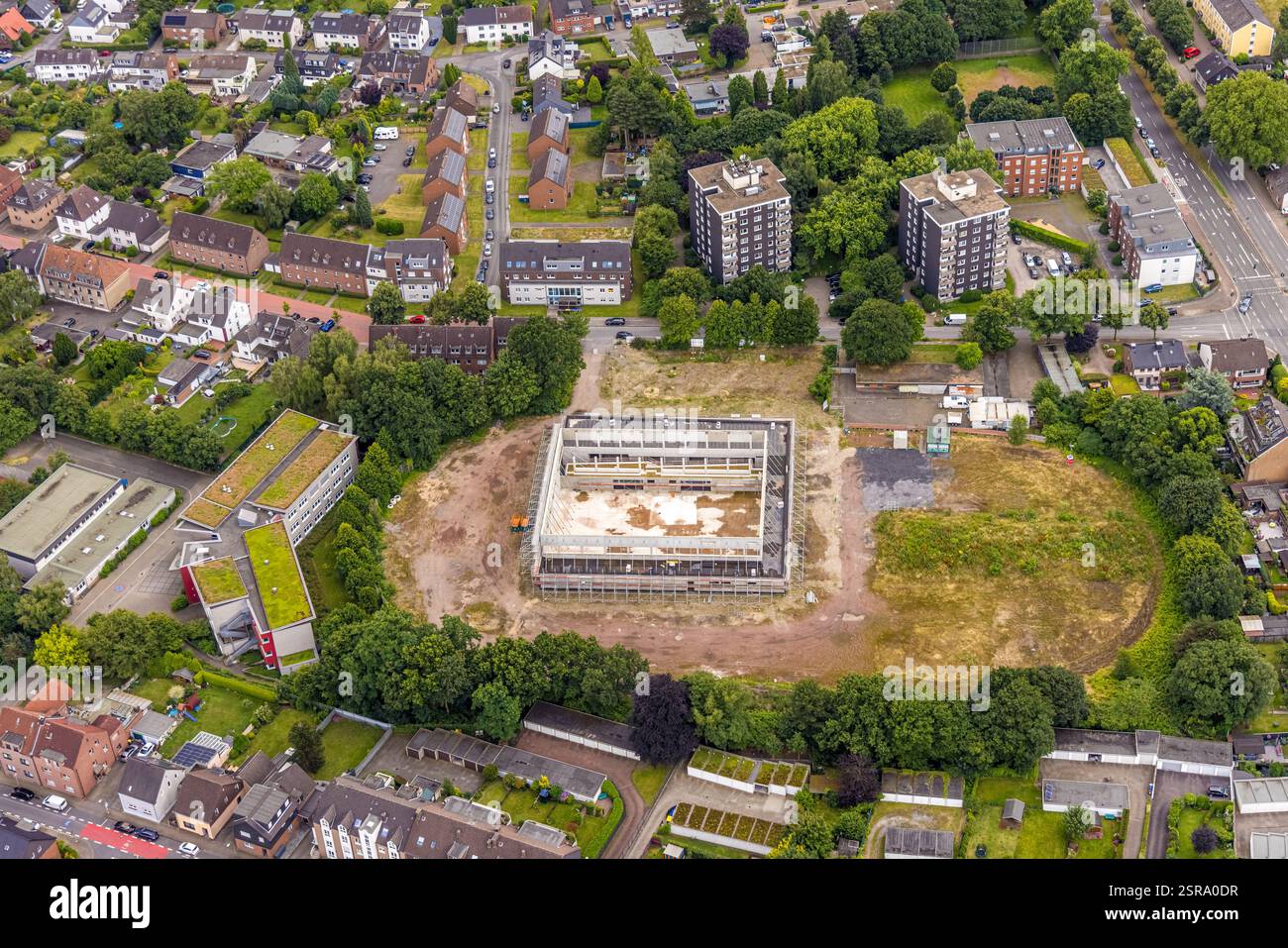 Vista aerea, cantiere edile con nuovo palazzetto dello sport all'angolo tra Neustraße e Westring sull'ex campo sportivo, complesso residenziale e grattacielo b Foto Stock