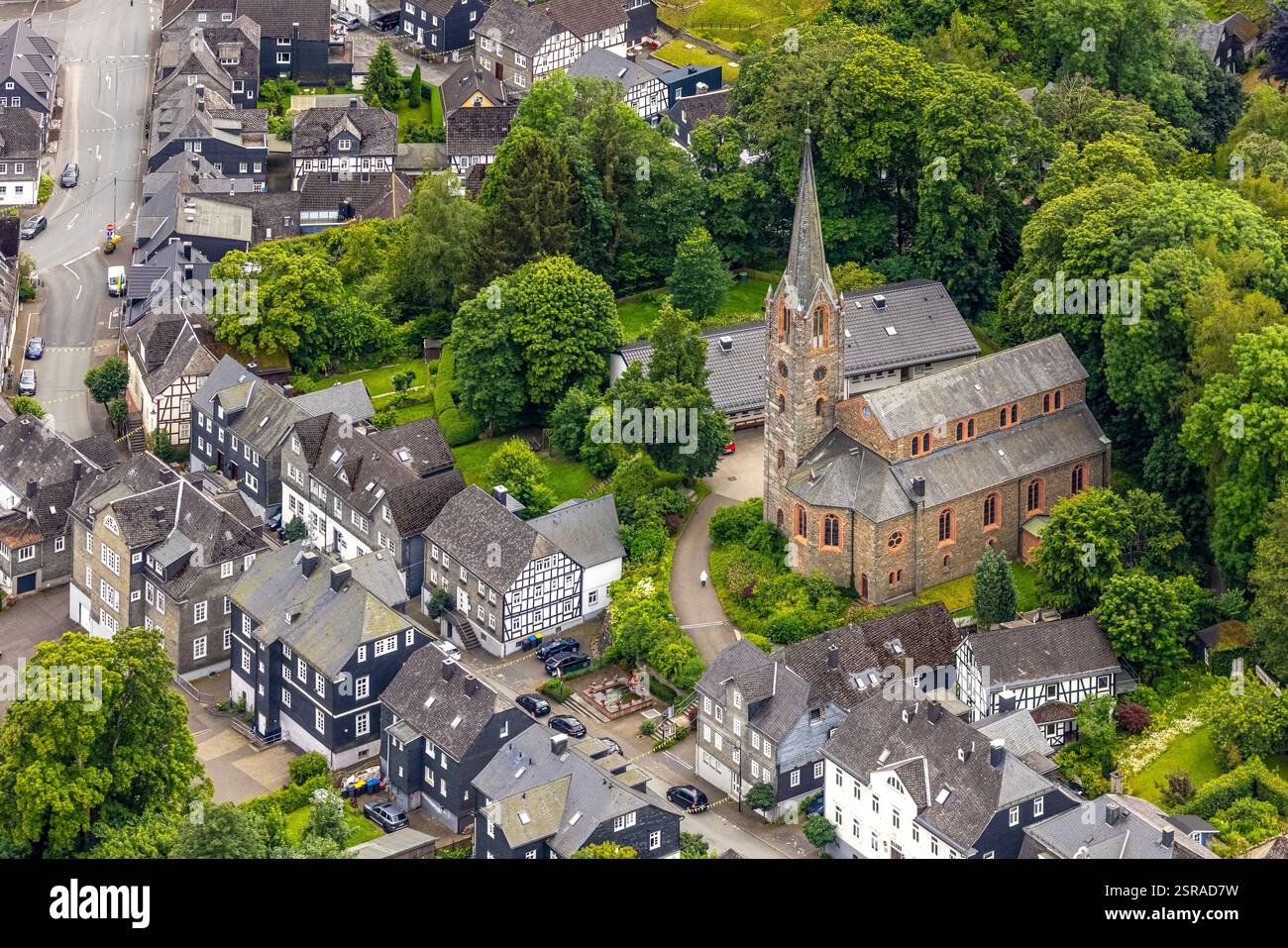 Vista aerea, chiesa protestante e alberi verdi su Schloßstraße, zona residenziale con case storiche Bad Berleburg, Wittgensteiner Land, North R Foto Stock