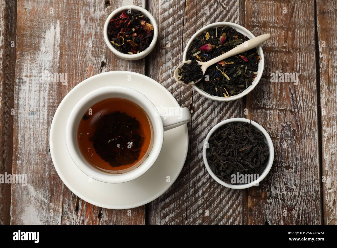 Tè aromatico e foglie secche su un tavolo di legno, piano Foto Stock