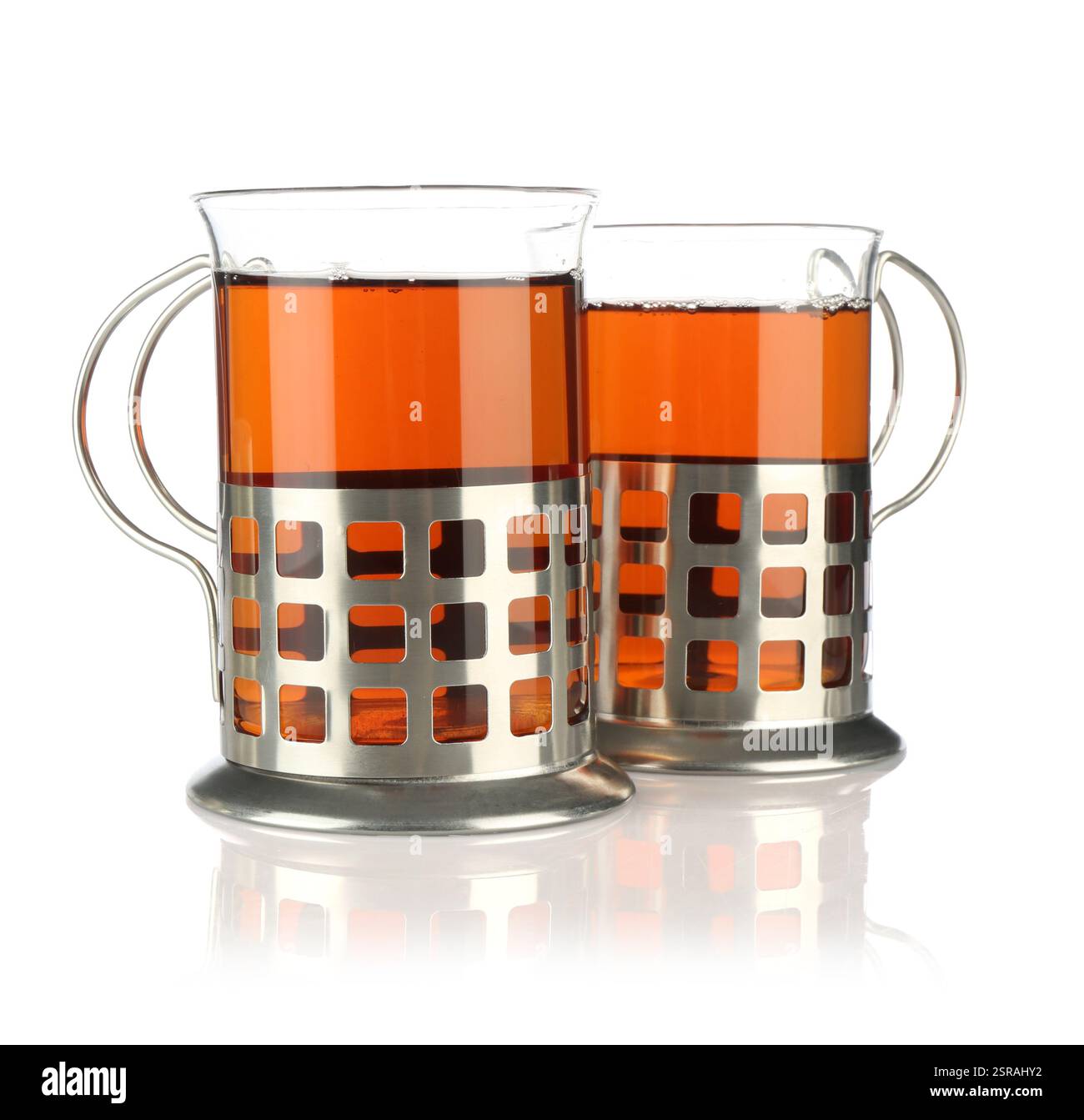 Bicchieri di tè aromatico in contenitori isolati su bianco Foto Stock