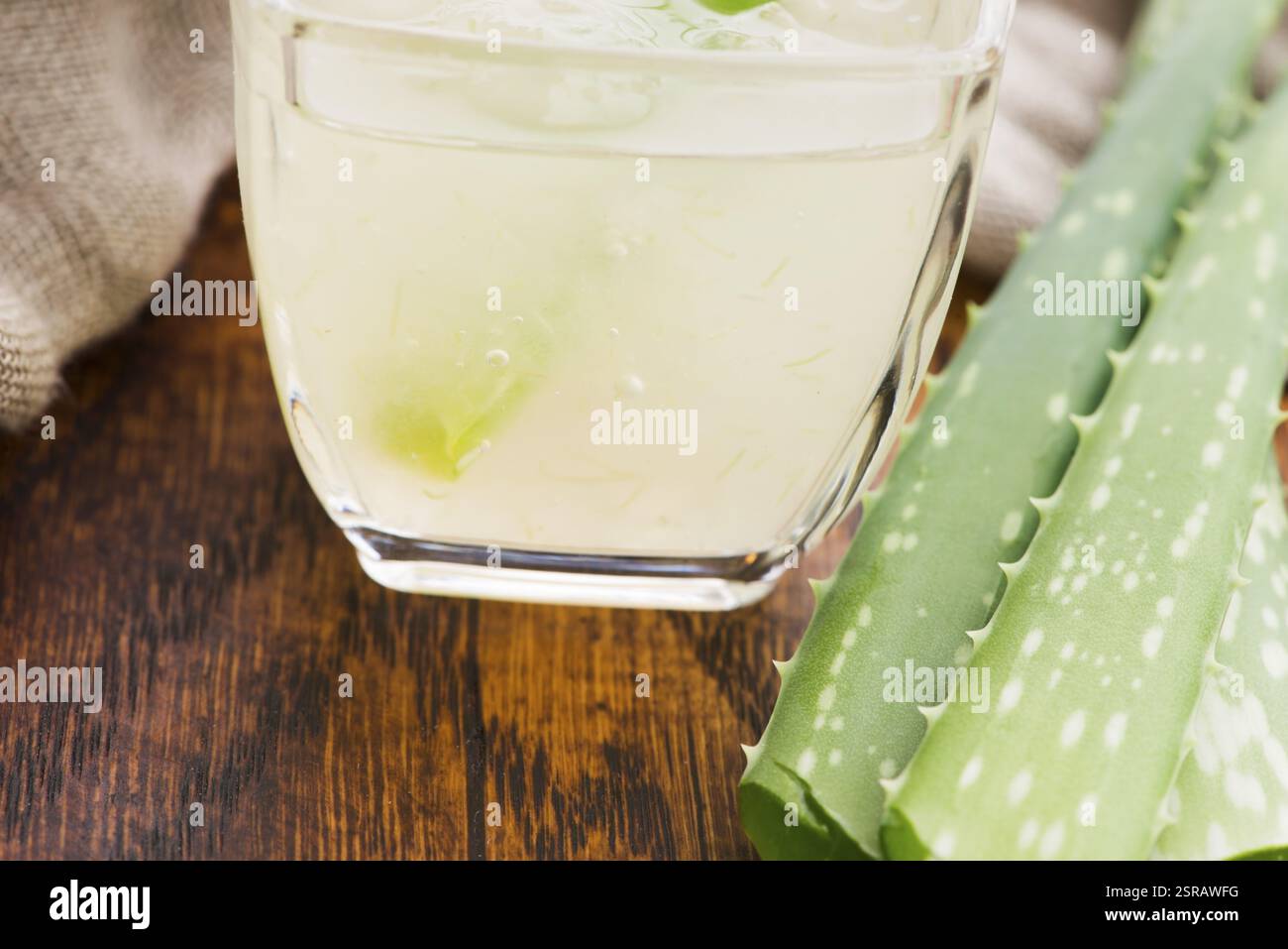 Vetreria con succo di aloe vera fresco e foglie Foto Stock