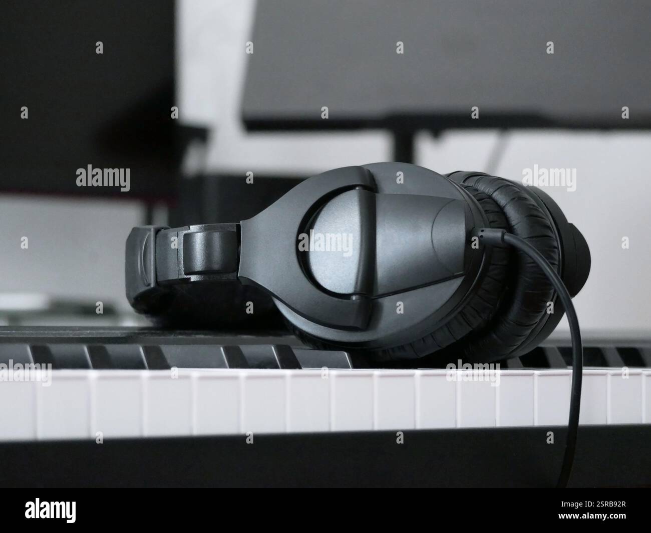Le cuffie si trovano sui tasti del sintetizzatore. Auricolare su un pianoforte elettronico. Creazione di musica e registrazione audio. Foto Stock