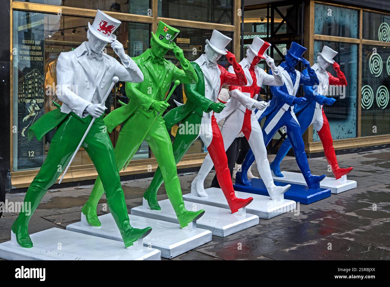 Johnnie Walker Whisky statue di striding man in colori Six Nations rugby fuori dall'esperienza Johnnie Walker in Princes Street, Edimburgo. Foto Stock