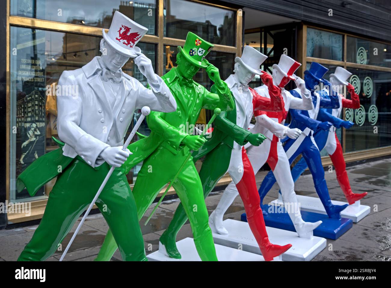 Johnnie Walker Whisky statue di striding man in colori Six Nations rugby fuori dall'esperienza Johnnie Walker in Princes Street, Edimburgo. Foto Stock