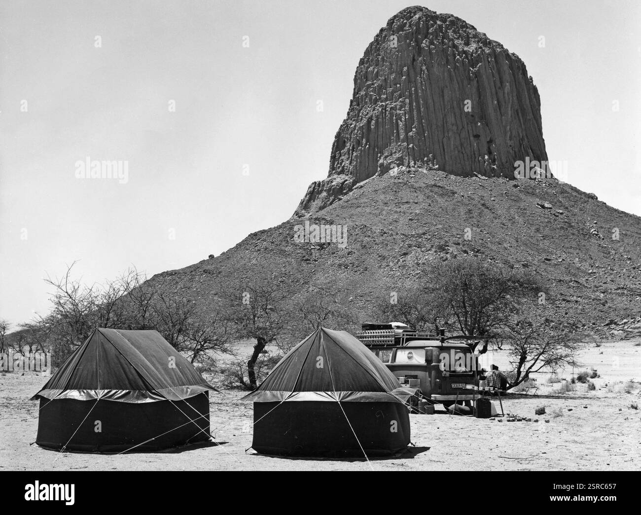 Aufgeschlagene Zelte inmitten der riesigen Sahara und vor dem PIC Laperina, Sahara 1970 Jahre. Foto Stock