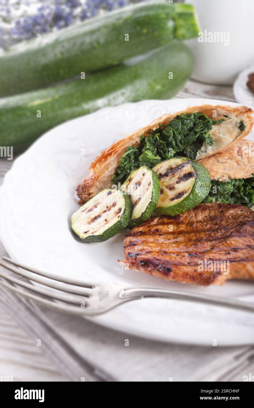 Bistecche alla griglia con sacchetto di pasta sfoglia e zucchine Foto Stock