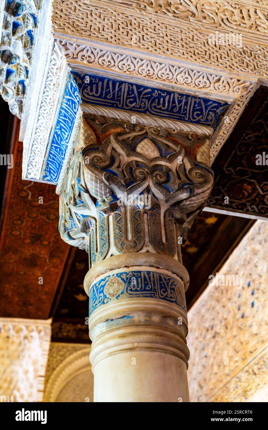 Squisita calligrafia islamica e disegni geometrici ornati sul pilastro storico dell'Alhambra a Granada, Spagna Foto Stock