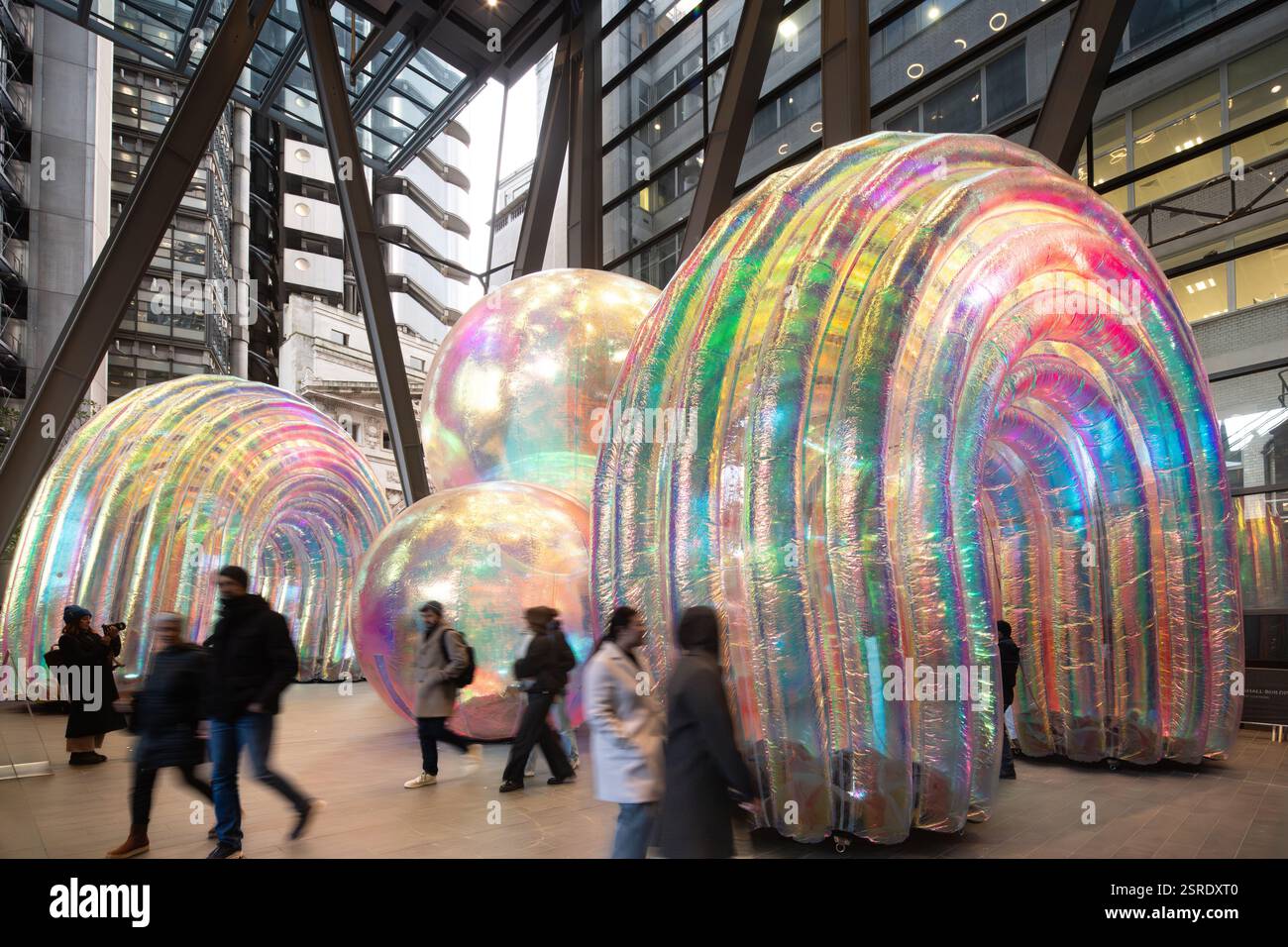 I visitatori camminano davanti a iridescenti strutture gonfiabili presso il Leadenhall Building di Londra. Installazione artistica. Foto Stock
