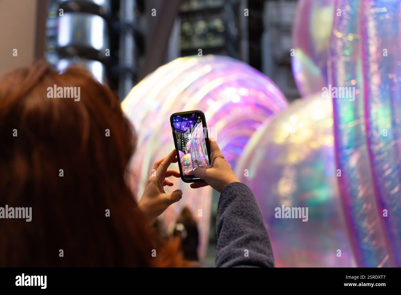 La persona fotografa un'installazione artistica iridescente al Leadenhall Building, Londra. Foto Stock