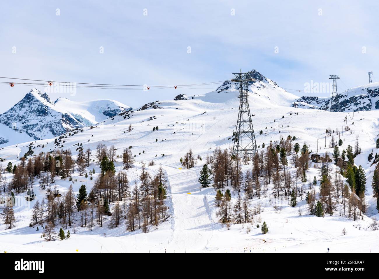 Vista di un comprensorio sciistico di alta montagna nelle Alpi svizzere in una giornata parzialmente nuvolosa Foto Stock