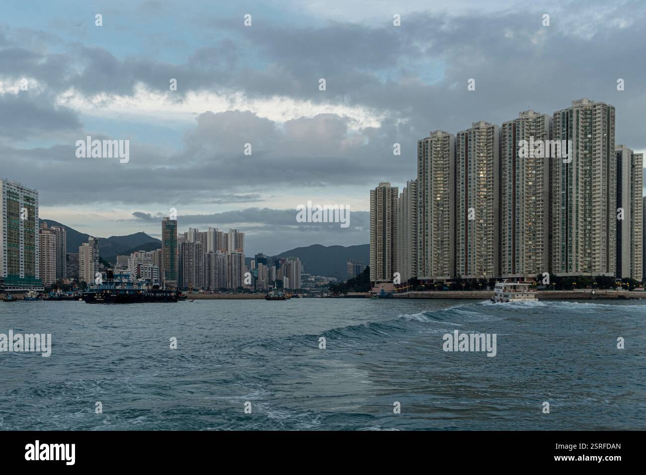L'ingresso al Typhoon Shelter di Aberdeen, visto attraverso il canale di East Lamma, mostra un suggestivo lungomare urbano con edifici alti. Foto Stock L'ingresso al Typhoon Shelter di Aberdeen, visto attraverso il canale di East Lamma, mostra un suggestivo lungomare urbano con edifici alti. Foto Stock