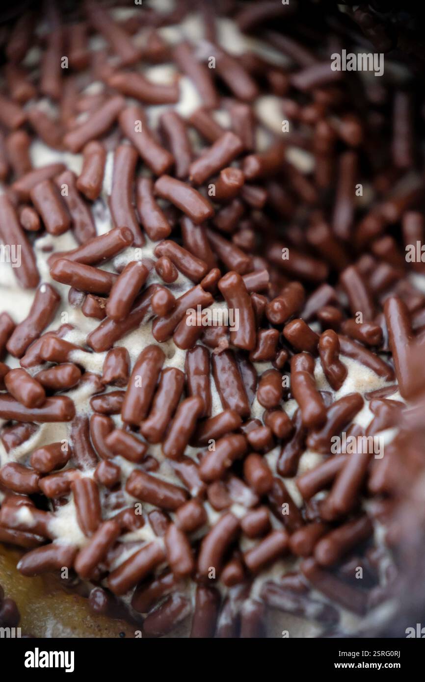 Primo piano di cioccolato cospargere su una ciambella. Foto Stock
