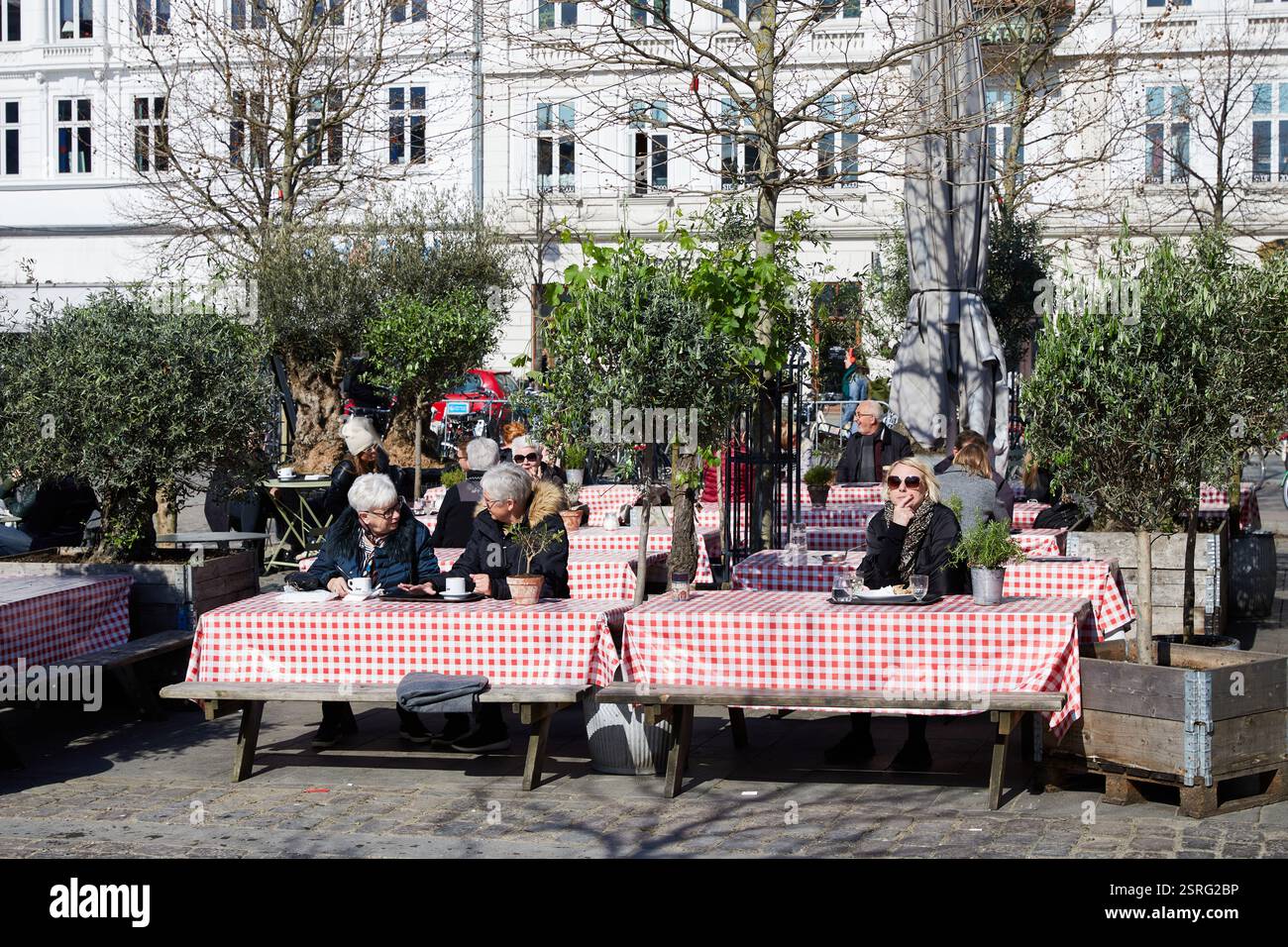 Persone sedute fuori Torvehallerne, inizio primavera; Copenaghen, Danimarca Foto Stock