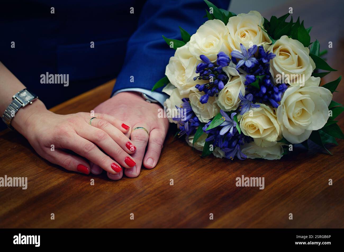 Mani con anelli e bouquet. Concetto per matrimoni e nuove celebrazioni matrimoniali. Foto Stock