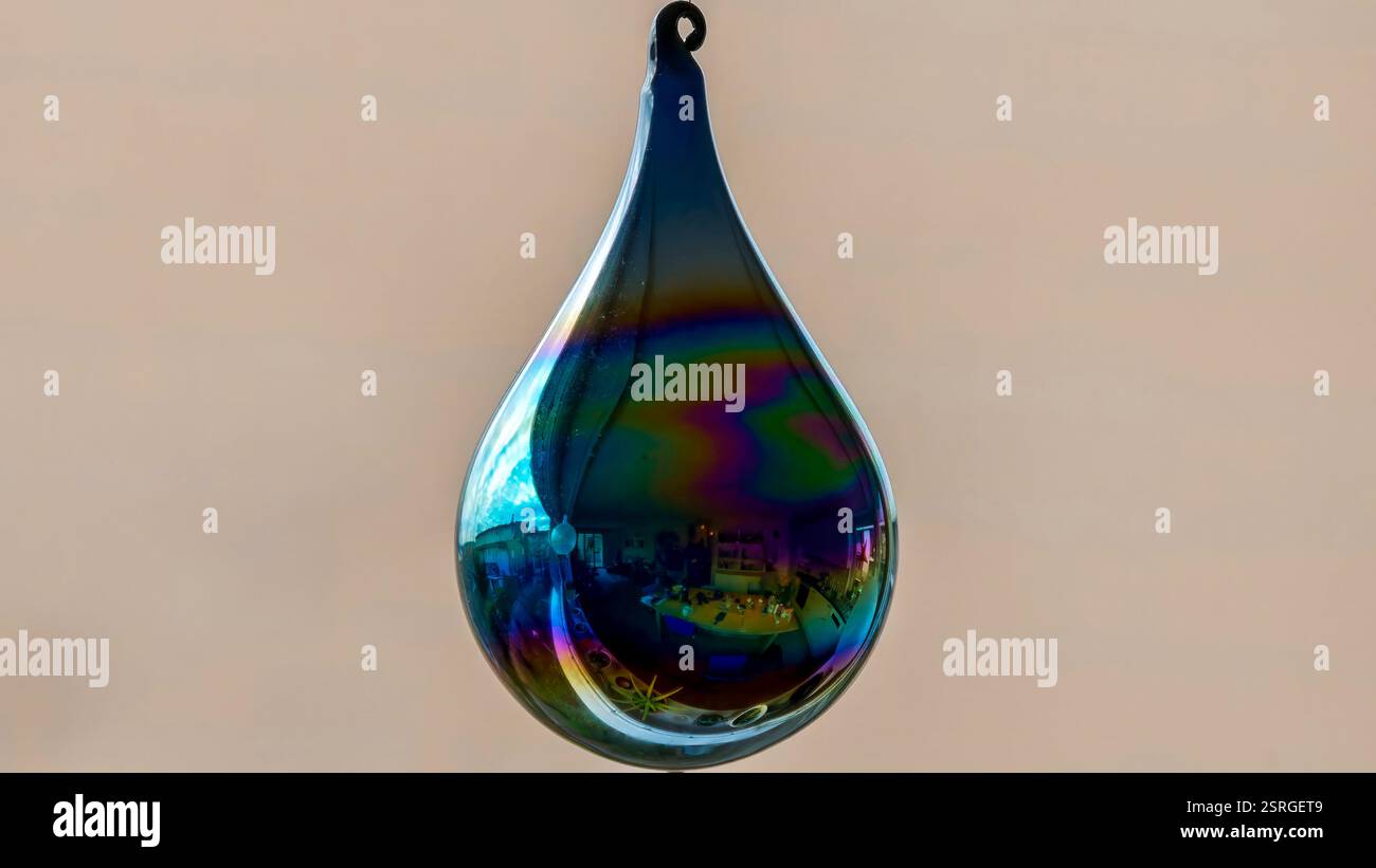 Decorazione a goccia di vetro iridescente che riflette il paesaggio urbano su sfondo morbido Foto Stock