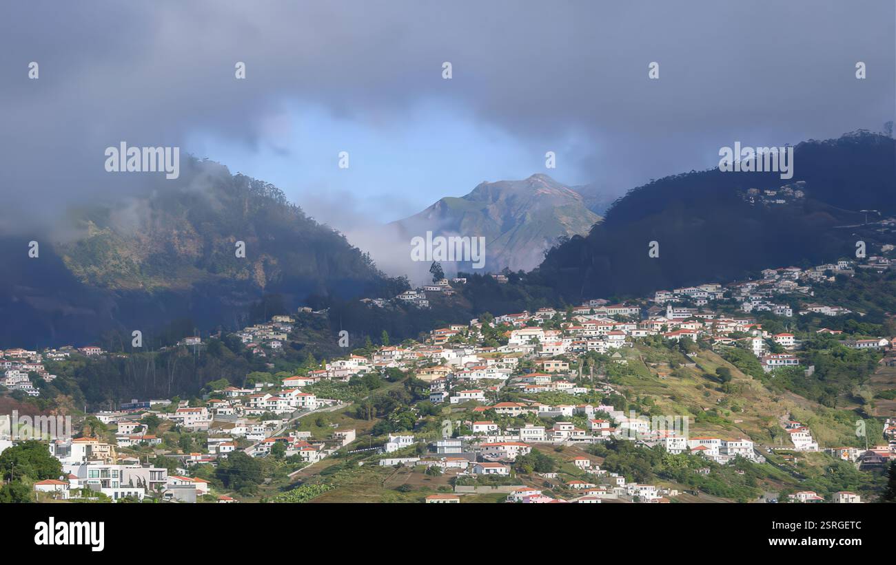 Vista panoramica del villaggio di montagna sotto le nuvole spettacolari e il paesaggio vivace Foto Stock