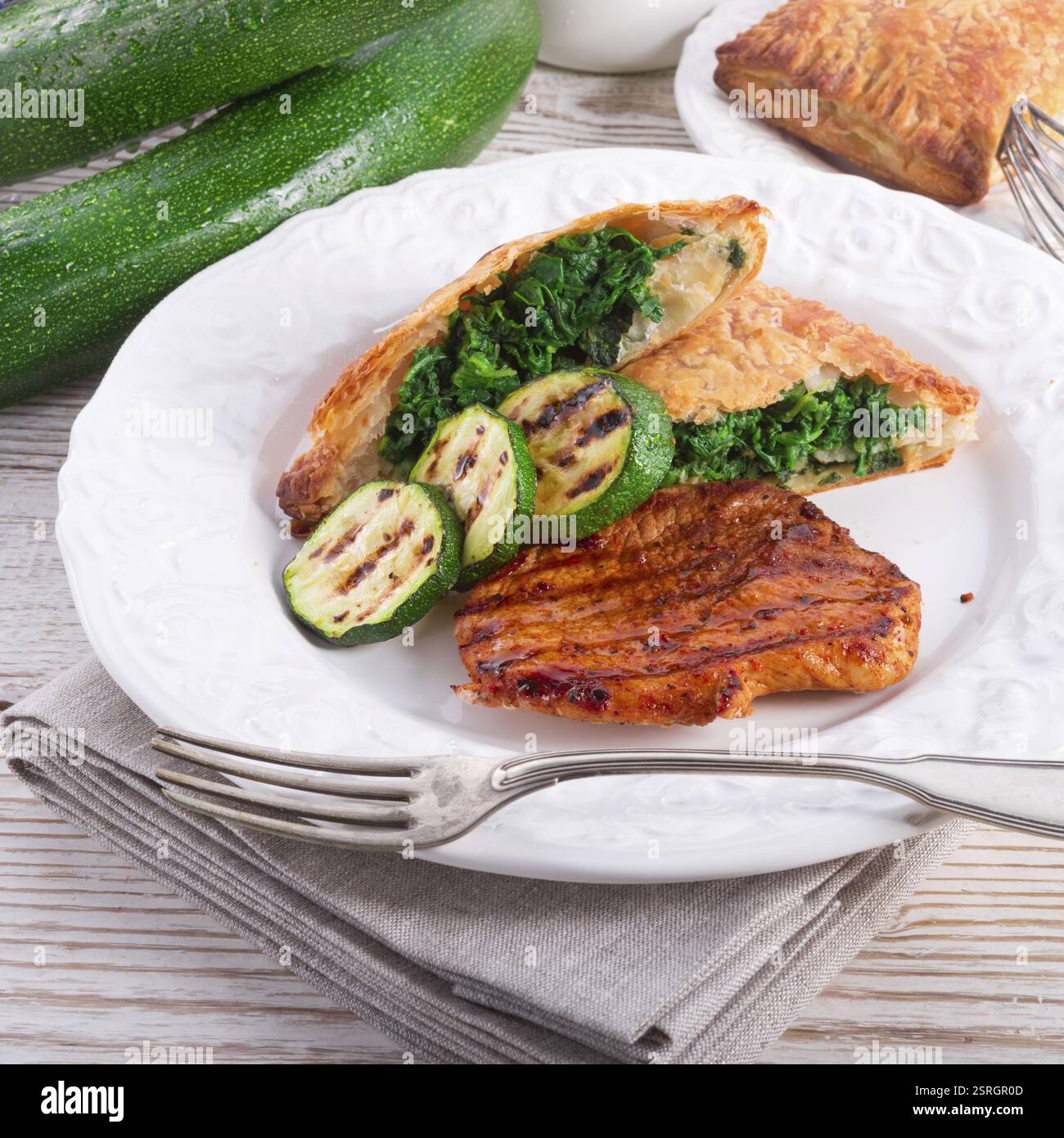 Bistecche alla griglia con sacchetto di pasta sfoglia e zucchine Foto Stock