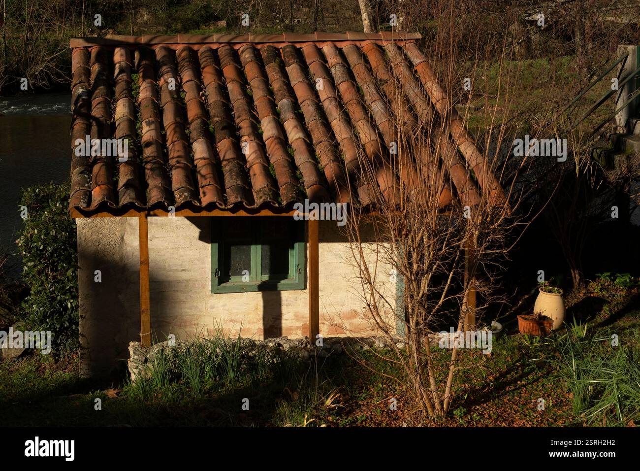 Tranquillo scenario invernale con una piccola casa alla luce del sole mattutino a Mas D'Azil, Ariege, Francia. Foto Stock