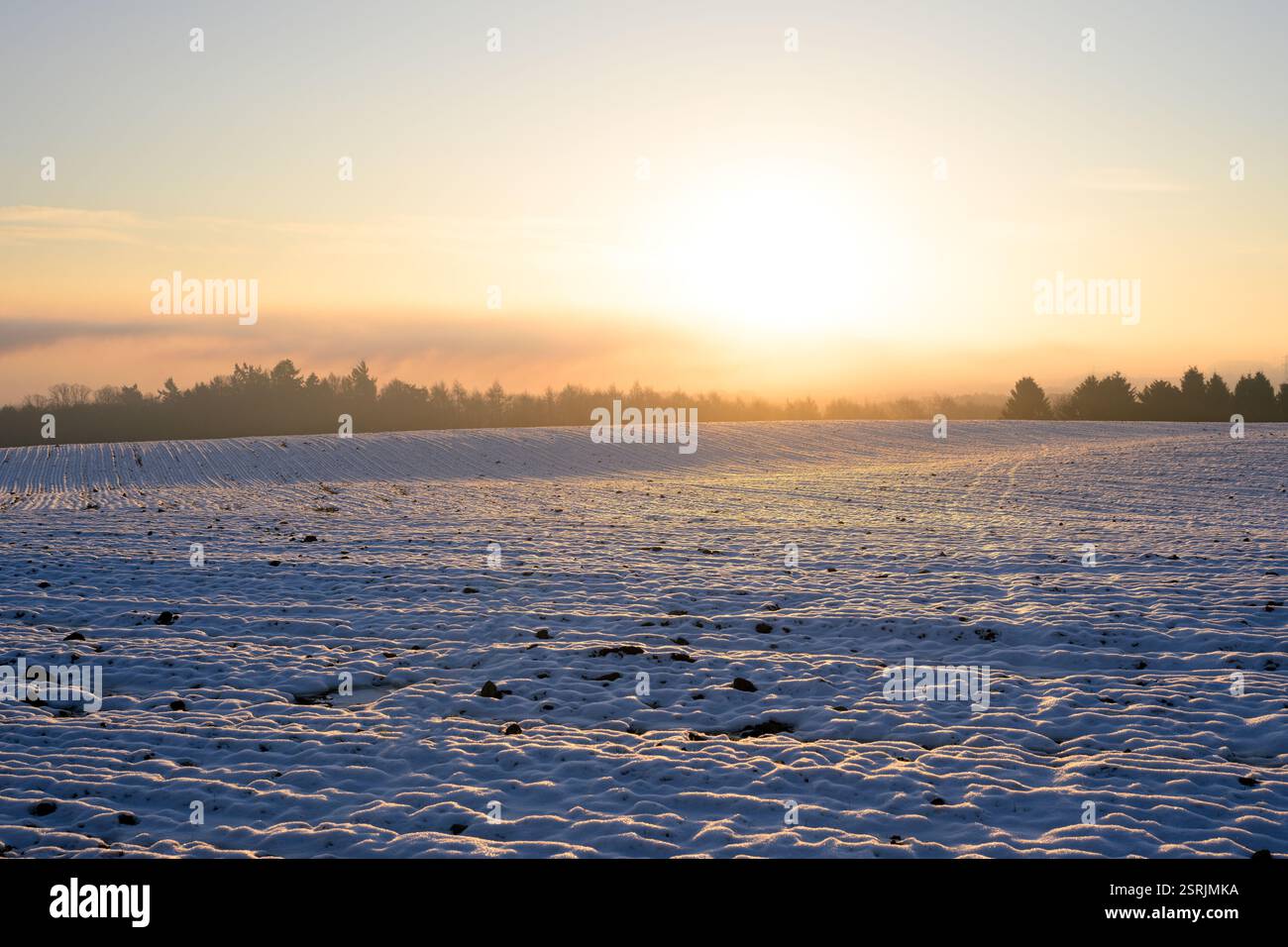 Colline panoramiche nella campagna britannica con un'alba invernale con sole basso all'orizzonte. Foto Stock