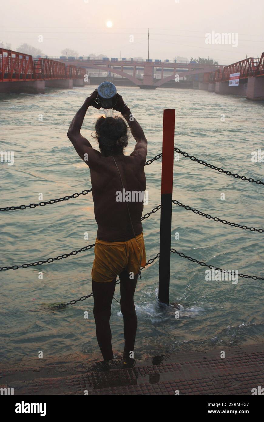 Sacerdote che fa il bagno sacro a har ki pouri ad Haridwar, Uttaranchal Uttarakhand, India, Asia Foto Stock