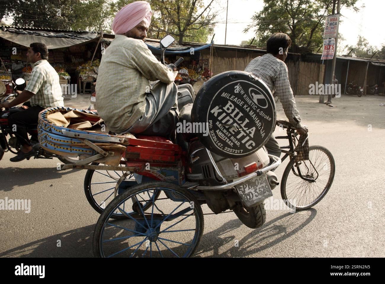 Sikh man trasporta due ruote defunte su risciò in bicicletta, Amritsar, Punjab, India, Asia Foto Stock
