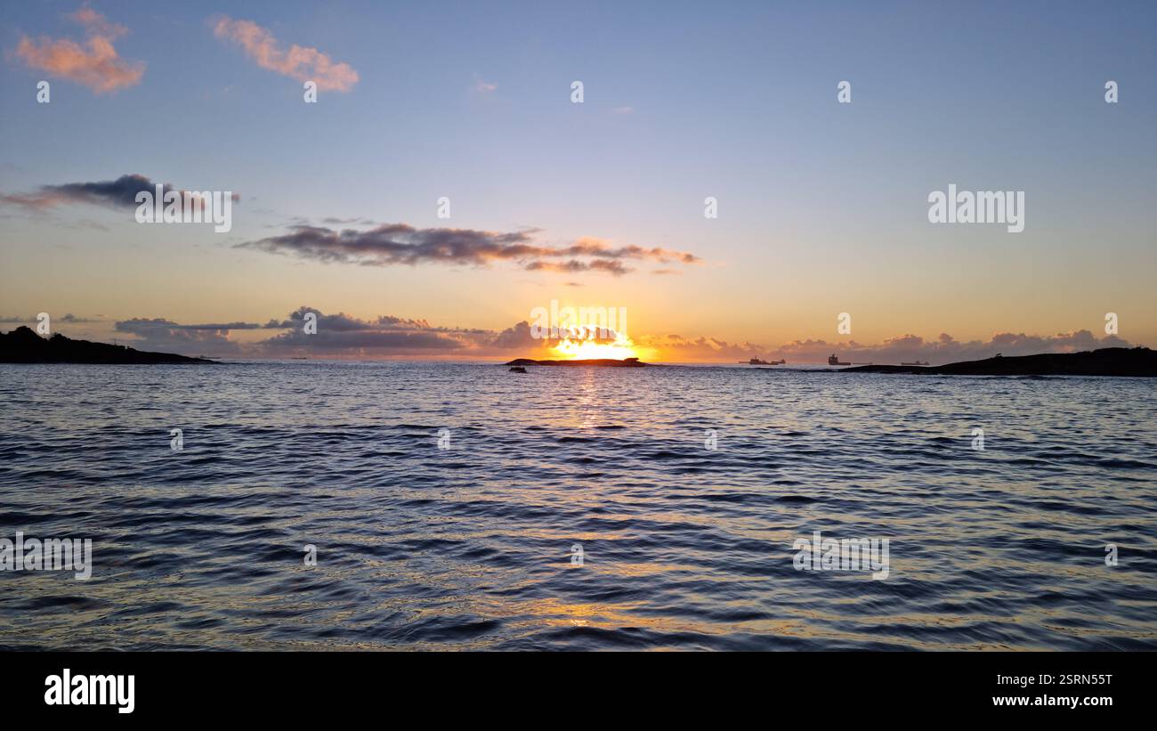 Questa foto mozzafiato cattura la serenità dell'alba sull'oceano aperto. Foto Stock
